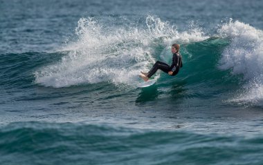 Surfer in Ribeira de Ilhas Beach in Ericeira Portugal.