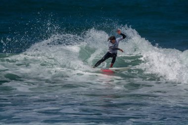Surfer in Ribeira de Ilhas Beach in Ericeira Portugal.