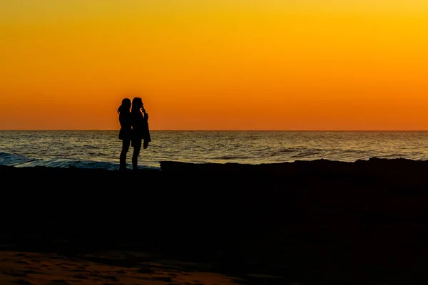 Duas meninas relaxante assistindo o pôr do sol — Fotografia de Stock