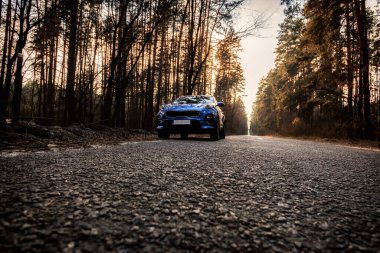 Kyiv, Ukraine - 26.03.2020 Blue Kia Sportage in the forest at sunset time clipart