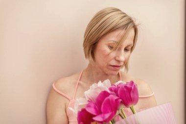 Baharda elinde bir buket lale olan bir kadın.
