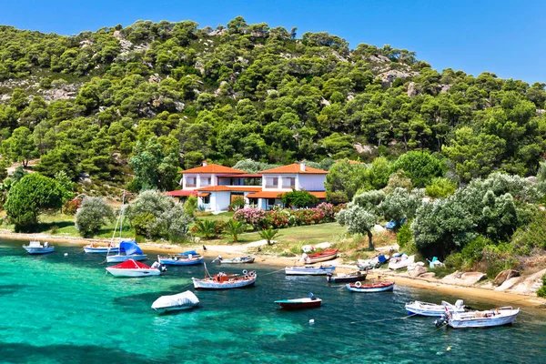 Båtar och yachter förtöjda nära villan i ett avskilt läge på Egeiska havet Royaltyfria Stockfoton