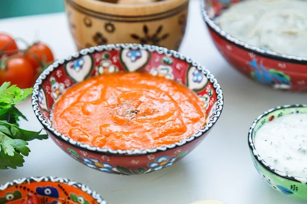 Små boller med hjemmelaget harissa og tzatziki med meze på et bord . – stockfoto