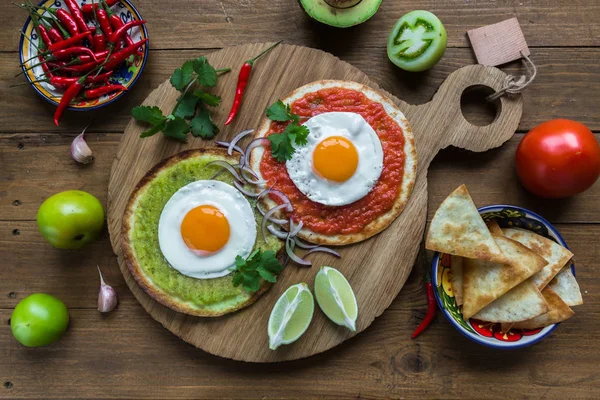 Huevos divorciados, huevos fritos en tortillas de maíz con salsa verde y roja, desayuno mexicano —  Fotos de Stock