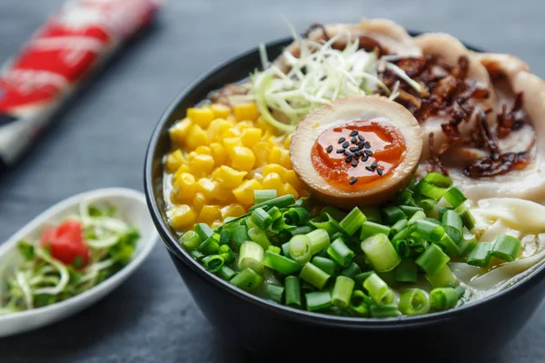 Ramen tonkotsu, soupe de nouilles japonaise avec ventre de porc, maïs, oignon de printemps et nitamago sur le dessus — Photo