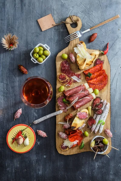 Diferentes embutidos españoles sobre una mesa: jamón, chorizo, salami, queso y vino. Vista superior — Foto de Stock