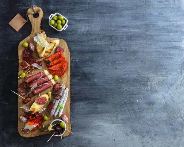 Tipico concetto spagnolo di tapas. includere varietà fette di marmellata, chorizo, salame, ciotole con olive, peperoni, acciughe, patate piccanti, purè di ceci su un tavolo di legno. Copyspace — Foto Stock