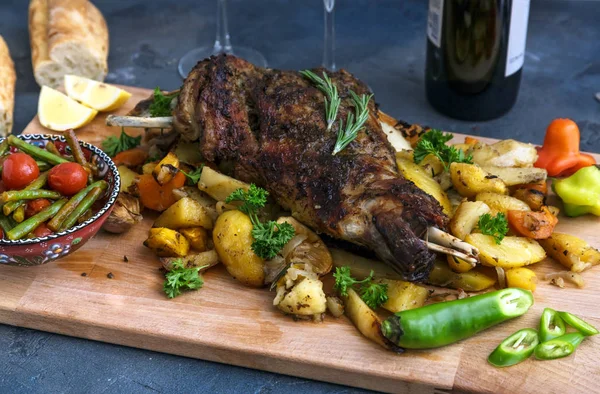 Gebraden lam schouder met geroosterde aardappelen en wortelen stijl in een rustieke houten plank, bovenaanzicht — Stockfoto