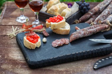 Making pintxo with tomato and sausages, tapas, spanish canapes party finger food clipart
