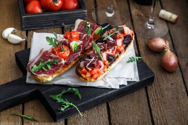 Ahşap bir masa üzerinde dilimleri jamon serrano, salam, zeytin ve peynir küplerini İspanyolca tapas. İspanya mutfağı