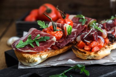 Bruschetta proschuto, domates, kaşar peyniri ve roka ile kapatmak