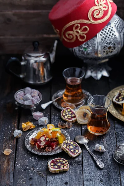 Thé turc traditionnel avec des bonbons orientaux traditionnels, fond sombre — Photo