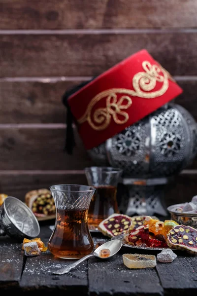 Thé turc avec des tasses en verre authentiques. Deux tasses de thé turc et des bonbons sur fond de bois sombre — Photo