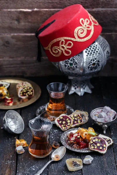 Turkish tea with authentic glass cups. Two cups of turkish tea and sweets on dark wood background — Stock Photo, Image