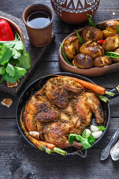 Frango assado inteiro em uma panela de ferro no fundo escuro — Fotografia de Stock