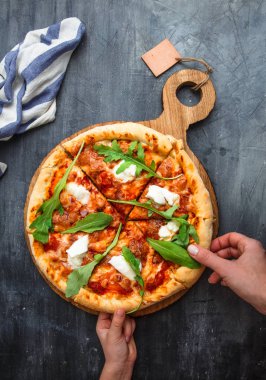 Dilim Pizza Margherita alarak elleriyle. Siyah arka plan.