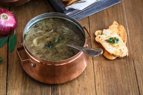 Луковый суп в медном котле с луком на заднем плане, деревенский стиль — стоковое фото