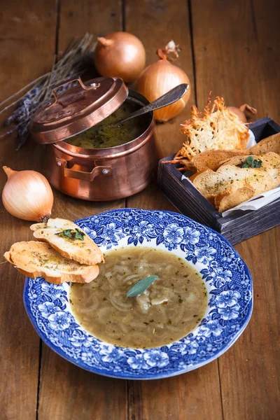 Луковый суп с сырным крутоном в тарелке — стоковое фото