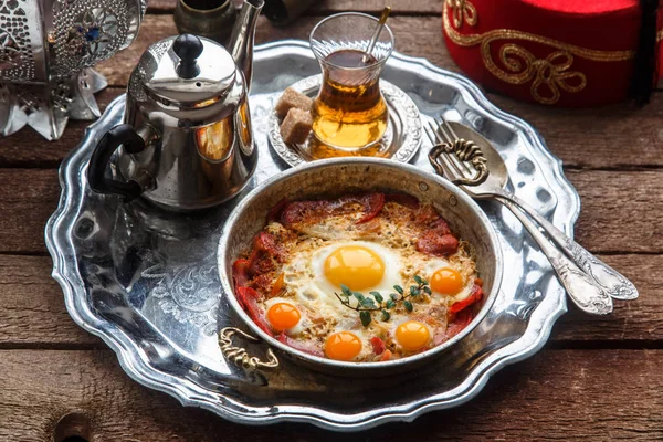 Huevo frito con carne curada, desayuno tradicional turco, servido en vajilla de metal, rústico —  Fotos de Stock