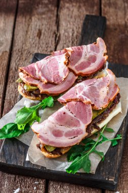 Jambon füme, soğan reçeli, cucubbers ve kara tahta, rustik tarzı üzerinde roket salata sandviç