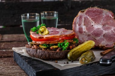 Tütsülenmiş jambon, domates, soğan reçel, turşu ve votka ile ev yapımı çavdar sandviç.