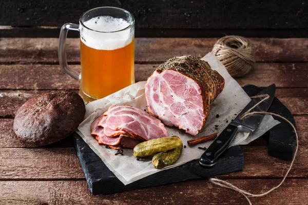 Bira ve turşu ile bir blackwooden tahtada lezzetli füme jambon