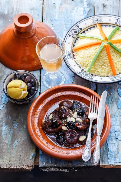 Pratos tradicionais marroquinos: tajine de vaca, cuscuz, azeitonas e limões salgados. Estilo rústico — Fotografia de Stock