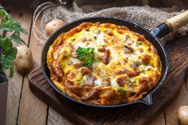 Fransız omlet Savoyarde pastırma, peynir ve pırasa kızartma tavası, rustik
