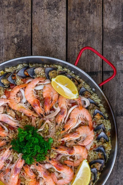 Paella tradicional de mariscos en la sartén en una mesa vieja de madera, vista superior —  Fotos de Stock