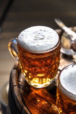 Bira bardağı ahşap bir varil üzerinde kurutulmuş balıklar ile