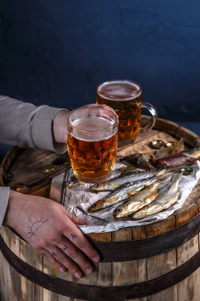 Man drink beer with dried fishes
