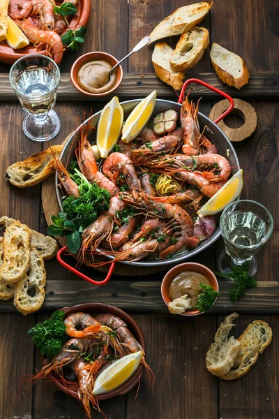 Cena de mariscos. Langostinos tigre a la parrilla en sartén con limón fresco, ajo, pan sobre fondo de madera, vista superior . — Foto de Stock