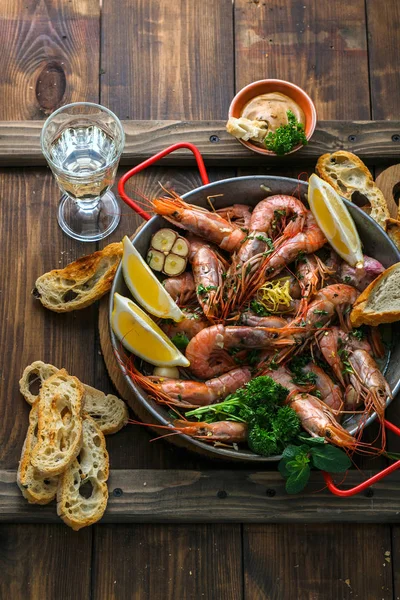 Camarones tigre en paellera con limón y pan — Foto de Stock