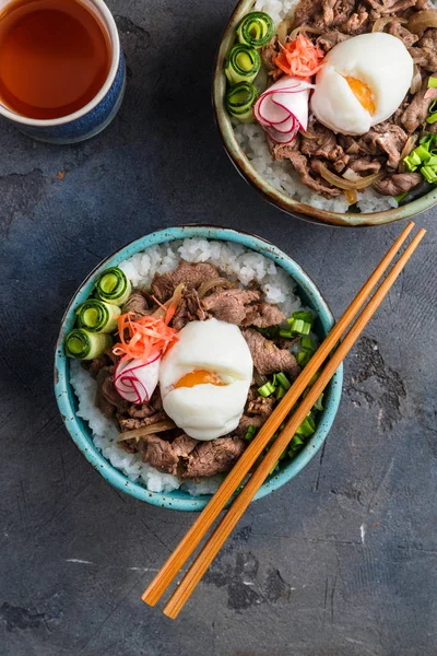 Dos tazones de carne de res o gyudon con huevo y cebolla vista superior —  Fotos de Stock