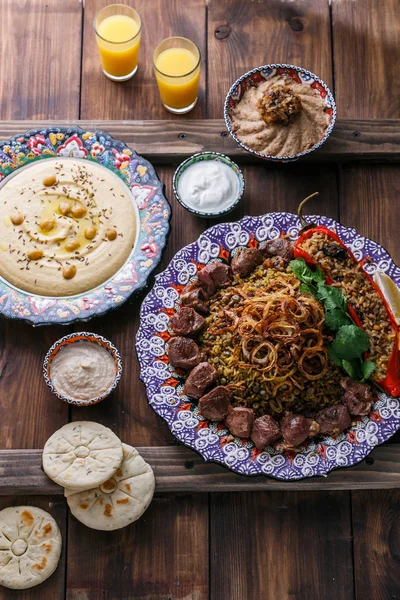 Mejadra con hummus, kashke bademjan y pitas, fondo de madera —  Fotos de Stock