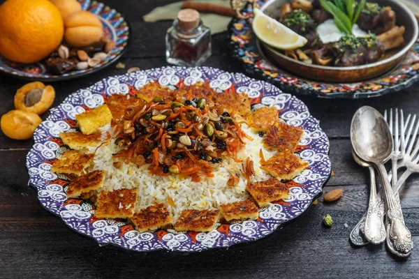 Pilaf iraní con ralladura de naranja, nueces y pasas, en un plato tradicional —  Fotos de Stock