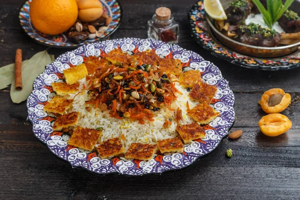 Pilaf iraní con ralladura de naranja, nueces y pasas, en un plato tradicional —  Fotos de Stock