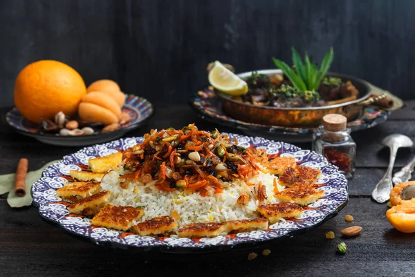 Pilaf iraní con ralladura de naranja, nueces y pasas, en un plato tradicional —  Fotos de Stock