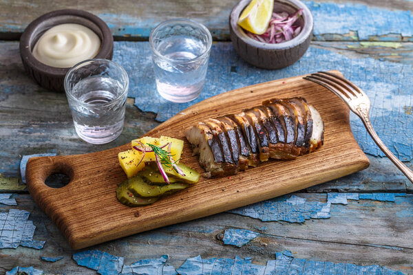 Кусочки копченого осетра на доске
