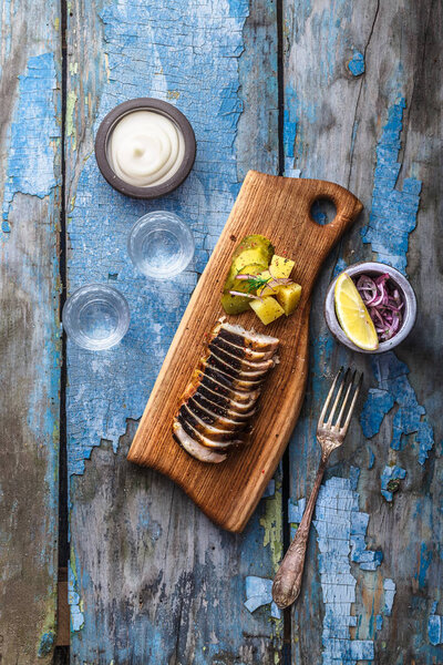 Кусочки копченого осетра на доске
