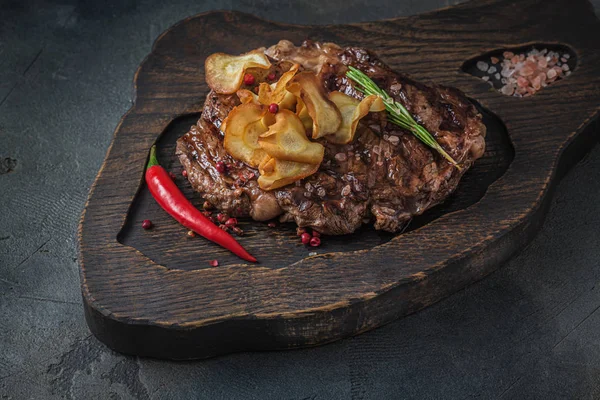 Beef chuck roll steak on wooden board, close view