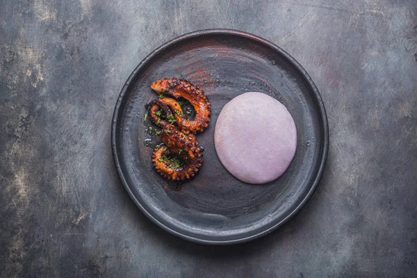 Щупальца осьминога с фиолетовым картофельным пюре, готовое блюдо — стоковое фото