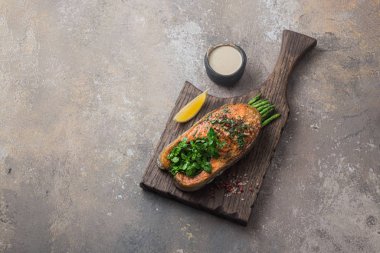 Ahşap tahtada kuşkonmaz ve kızarmış somon bifteği, kopyalama alanı.