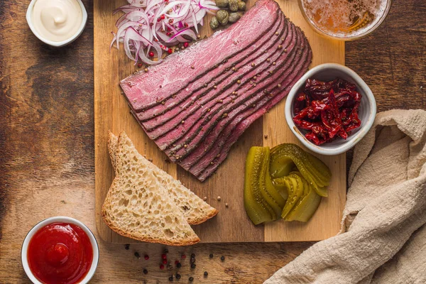 Κομμένο Deli Pastrami σε ξύλινη σανίδα, επίπεδη lay — Φωτογραφία Αρχείου