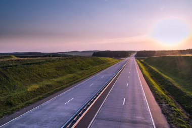 Ülke karayolu ve günbatımı. Açık yol büyük doğa çevresinde