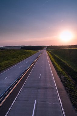 Ülke karayolu ve günbatımı. Açık yol büyük doğa çevresinde