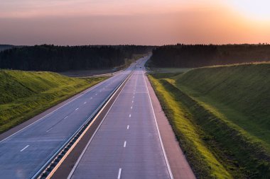 Ülke karayolu ve günbatımı. Açık yol büyük doğa çevresinde