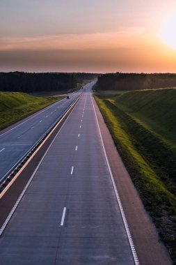 Ülke karayolu ve günbatımı. Açık yol büyük doğa çevresinde