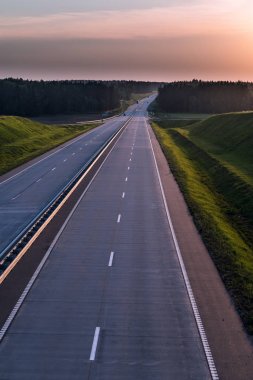 Ülke karayolu ve günbatımı. Açık yol büyük doğa çevresinde