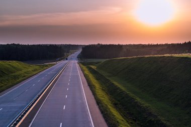 Ülke karayolu ve günbatımı. Açık yol büyük doğa çevresinde